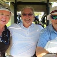 Three people in golf cart